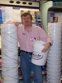 Owner John Fix holds one of the plastic buckets he normally sells, but which he gave to coupon-bearing customers so they could fill the bucket and earn an extra discount.
