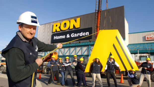 James Jones, Vice President, helps Rona employees at the former Building Box store in Toronto to put finishing touches on the store's new Rona Home & Garden banner.
